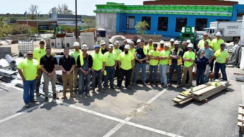 Construction team poses in front of PAW Center building during construction